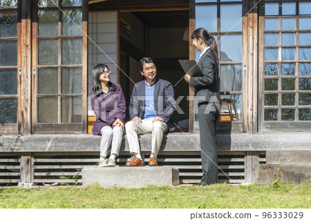 Senior couple and businesswoman talking on the far side of old houses 96333029
