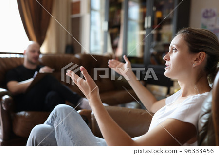 Female client taking with professional psychologist during psychotherapy session. Female client taking with professional psychologist during psychotherapy session. 96333456