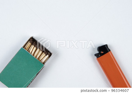Open grenn matchbox and orange plastic gas lighter on white background 96334607