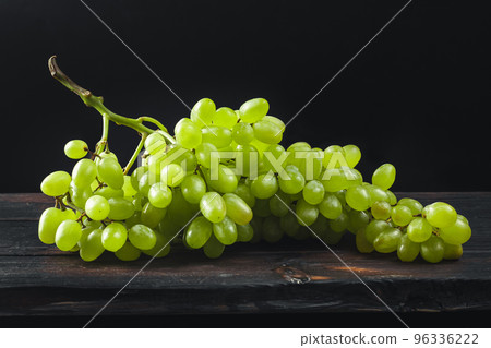 A bunch of grapes on the table. White grapes. Berries of grapes. 96336222