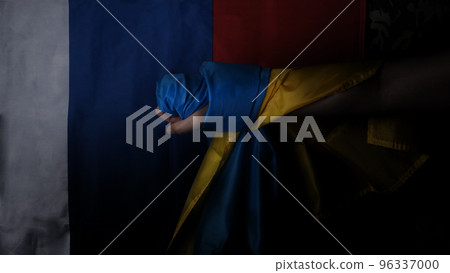 Russian flag and Ukrainian flag on a black background. Russian flag and Ukraine flag in hands showing symbol of struggle war political struggle political expressions Civil wars and territory conflict. 96337000