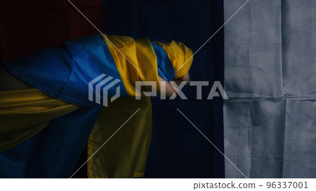 Russian flag and Ukrainian flag on a black background. Russian flag and Ukraine flag in hands showing symbol of struggle war political struggle political expressions Civil wars and territory conflict. 96337001
