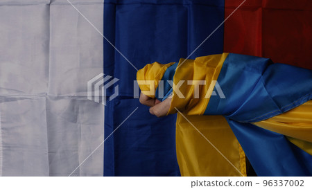 Russian flag and Ukrainian flag on a black background. Russian flag and Ukraine flag in hands showing symbol of struggle war political struggle political expressions Civil wars and territory conflict. 96337002