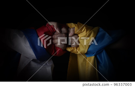 Russian flag and Ukrainian flag on a black background. Russian flag and Ukraine flag in hands showing symbol of struggle war political struggle political expressions Civil wars and territory conflict. 96337003