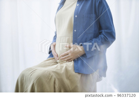 A pregnant woman wearing a blue shirt 96337120
