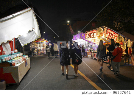 Families, friends, and lovers are attracted by the lights of the night stalls on the fair, and it is a happy time to eat, drink, and talk. 96337641