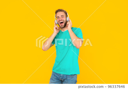 cheerful man in blue shirt wear earphones on yellow background, lifestyle cheerful man in blue shirt wear earphones on yellow background, lifestyle 96337646
