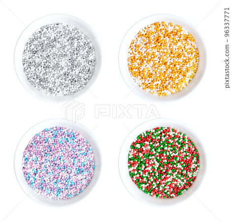Colored nonpareils in white bowls. Four colored mixes of decorative and edible confectionery of tiny balls, made with sugar and starch. Hundreds and Thousands, used as sweet decoration and as topping. 96337771