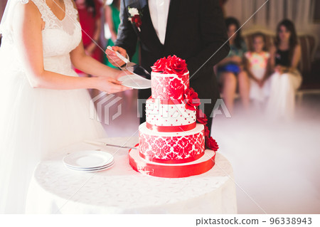 Bride and groom at wedding cutting the wedding cake 96338943