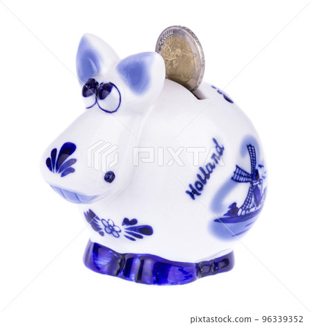 Piggy bank in a shape of a cow with blue ornament, coin falling Piggy bank in a shape of a cow with blue ornament, coin falling 96339352