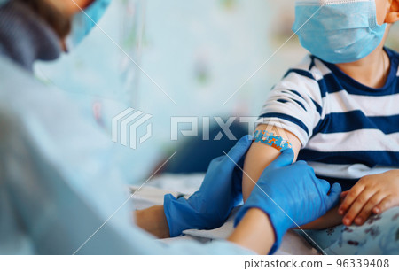Vaccination of little child at home. Children's hand with funny adhesive plaster. Vaccine for covid-19. 96339408