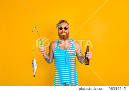 man with beard and swimsuit caught a fish 96339645
