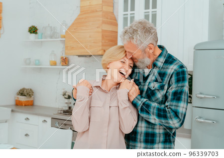 Retired husband and wife hug each other at home Retired husband and wife hug each other at home 96339703