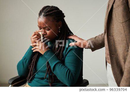 Crying young girl wiping tears with tissue while talking to psychologist about her condition Crying young girl wiping tears with tissue while talking to psychologist about her condition 96339704
