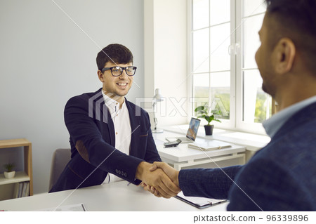 Two people meet in the office, make a successful business deal and exchanges handshakes 96339896