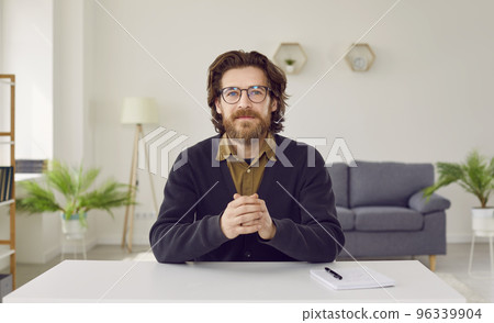 Portrait of businessman or teacher sitting at working desk during video conference Portrait of businessman or teacher sitting at working desk during video conference 96339904