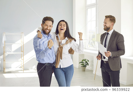 Happy married couple is joyfully and contentedly clenching their fists during meeting with realtor. 96339922