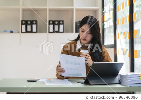 Asian young woman seriously working on computer laptop in house. She thinking find solution problem of work Asian young woman seriously working on computer laptop in house. She thinking find solution problem of work 96340080