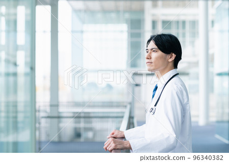 Young male doctor looking out the window 96340382