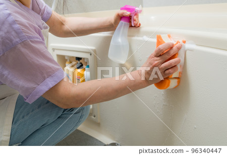[Middle housewife cleaning the bath with spray and bubbles] 96340447