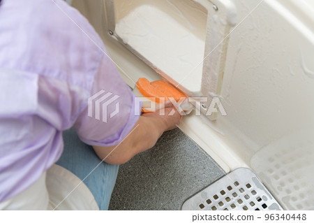 [Middle housewife cleaning the drain of the bathroom] 96340448