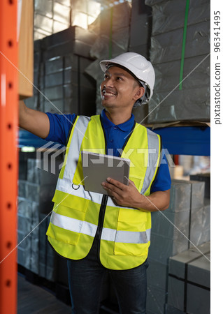 Working at warehouse. Male warehouse worker checking in storage department. Employee organizing goods distribution to the market. Working at warehouse. Male warehouse worker checking in storage department. Employee organizing goods distribution to the market. 96341495
