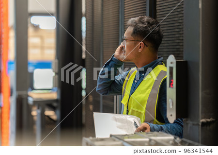Working at warehouse. Male warehouse worker checking in storage department. Employee organizing goods distribution to the market. Working at warehouse. Male warehouse worker checking in storage department. Employee organizing goods distribution to the market. 96341544