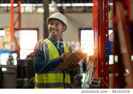 Working at warehouse. Male warehouse worker checking in storage department. Employee organizing goods distribution to the market. Working at warehouse. Male warehouse worker checking in storage department. Employee organizing goods distribution to the market. 96341626