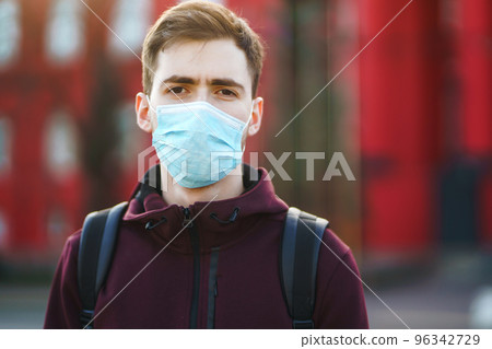Portrait of men in protective sterile medical mask on her face on the street city. pandemic in quarantine city. Portrait of men in protective sterile medical mask on her face on the street city. pandemic in quarantine city. 96342729