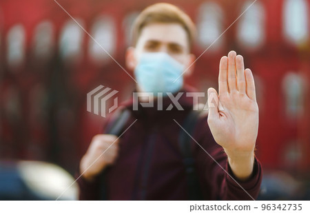 Portrait of men in protective sterile medical mask on her face on the street city. pandemic in quarantine city. Portrait of men in protective sterile medical mask on her face on the street city. pandemic in quarantine city. 96342735