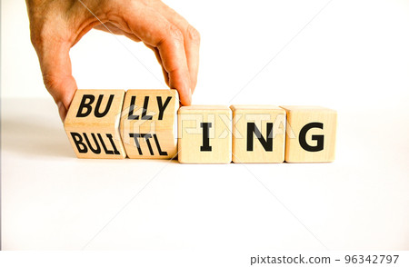 Bullying and belittling symbol. Concept words Bullying and Belittling on wooden cubes. Businessman hand. Beautiful white table white background. Business bullying and belittling concept. Copy space. 96342797