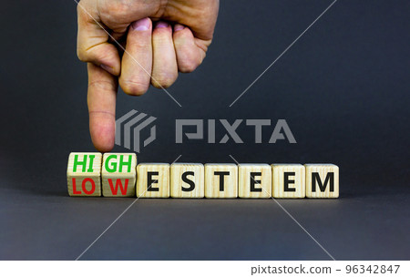 High or low esteem symbol. Concept words High esteem and Low esteem on wooden cubes. Businessman hand. Beautiful grey table grey background. Business high or low esteem concept. Copy space. 96342847