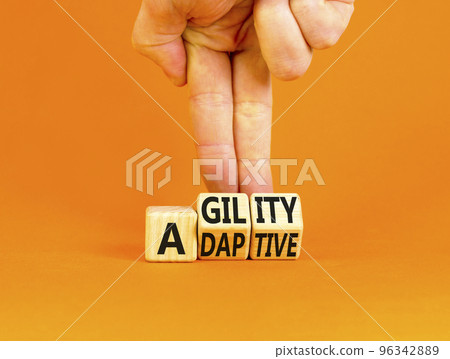 Agility and adaptive symbol. Concept words Agility and Adaptive on wooden cubes. Beautiful orange table orange background. Businessman hand. Business agility and adaptive concept. Copy space. 96342889