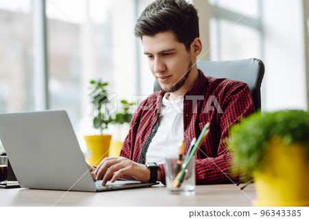 Young man working on laptop. Education and working online. Freelancer, technology, remote job. Young man working on laptop. Education and working online. Freelancer, technology, remote job. 96343385