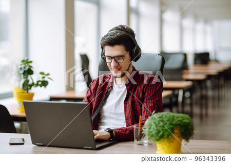 Young man working on laptop. Education and working online. Freelancer, technology, remote job. 96343396