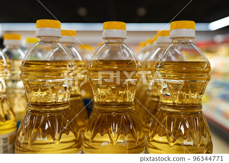 Yellow oil bottles (Soybean oil, Sunflower oil) selling on shelf at supermarket. Yellow oil bottles (Soybean oil, Sunflower oil) selling on shelf at supermarket. 96344771