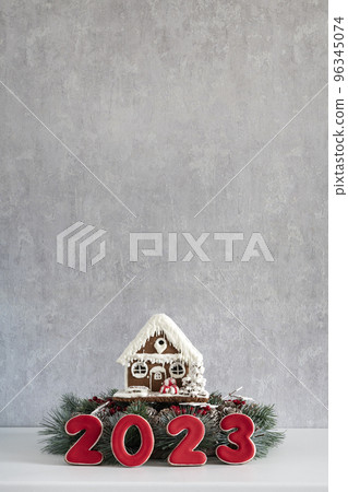 Gingerbread house and Inscription 2023. Merry Christmas background, copy space. Light gray wall on background 96345074