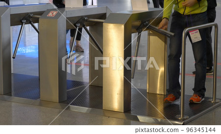 Man walks through the turnstile with his card to the validator 96345144