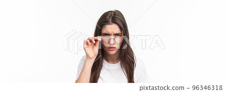 Close-up portrait of suspicious young serious-looking woman, look from under glasses, squinting at person with judgemental disbelief stare, standing white background, have doubts Close-up portrait of suspicious young serious-looking woman, look from under glasses, squinting at person with judgemental disbelief stare, standing white background, have doubts 96346318
