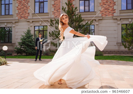 beautiful blonde bride dancing and whirling in front of the groom. beautiful blonde bride dancing and whirling in front of the groom. 96346607