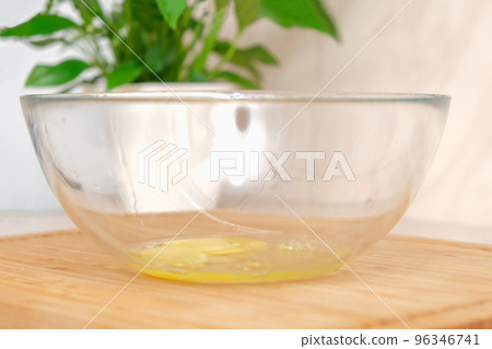 A man breaks a chicken egg on the edge of a A man breaks a chicken egg on the edge of a 96346741