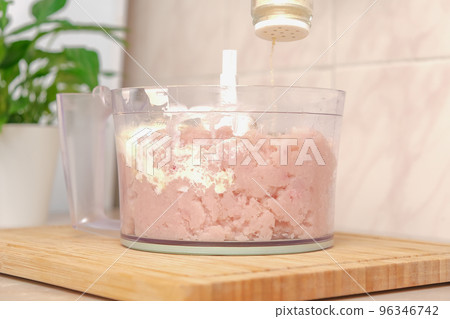 Man adds spices to food processor with chopped Man adds spices to food processor with chopped 96346742