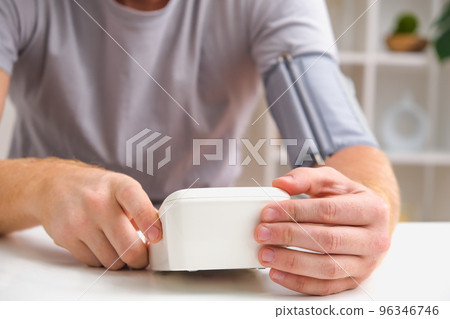 A man measures blood pressure with a white A man measures blood pressure with a white 96346746