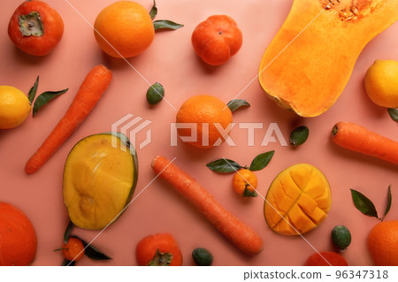 Ripe and tasty orange and yellow fruits, carrots and pumpkin around coral color background. flat lay Ripe and tasty orange and yellow fruits, carrots and pumpkin around coral color background. flat lay 96347318