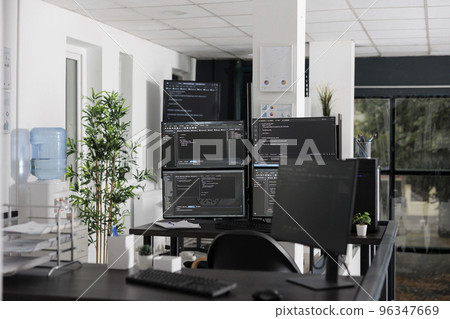 Pc desk with multiple monitors running terminal window and artificial intelligence programming database script. Empty software developing agency office with servers cloud computing Pc desk with multiple monitors running terminal window and artificial intelligence programming database script. Empty software developing agency office with servers cloud computing 96347669