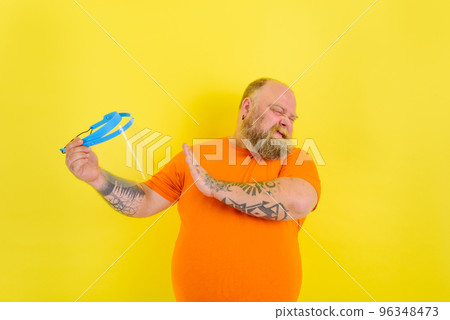 Doubter man with beard and tattoos is worried about a protective face shield against covid-19 96348473