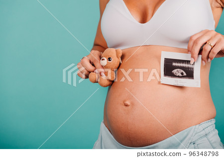 Pregnant mom shows an ultrasound of her son 96348798