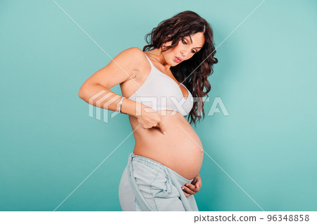 Pregnant amazed woman expecting a child caresses her belly 96348858