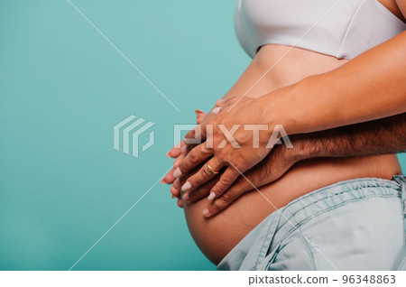 Pregnant woman expecting a child caresses her belly Pregnant woman expecting a child caresses her belly 96348863