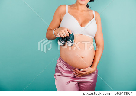 Pregnant woman expecting a child caresses her belly 96348904
